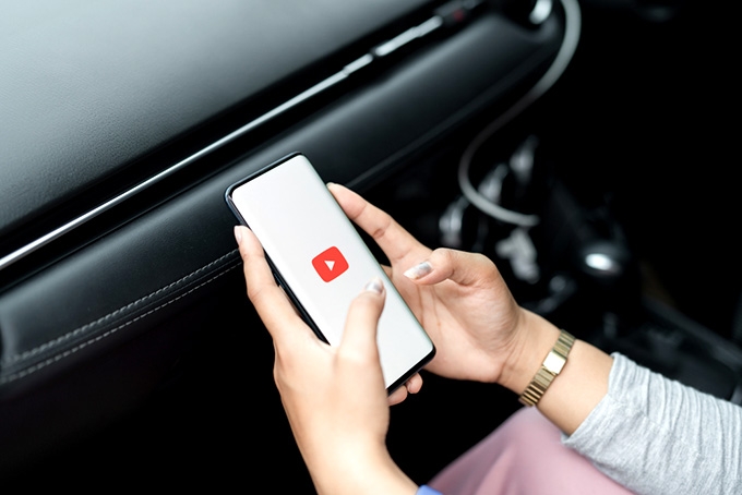 Coursera Python: woman watching Youtube on her phone.